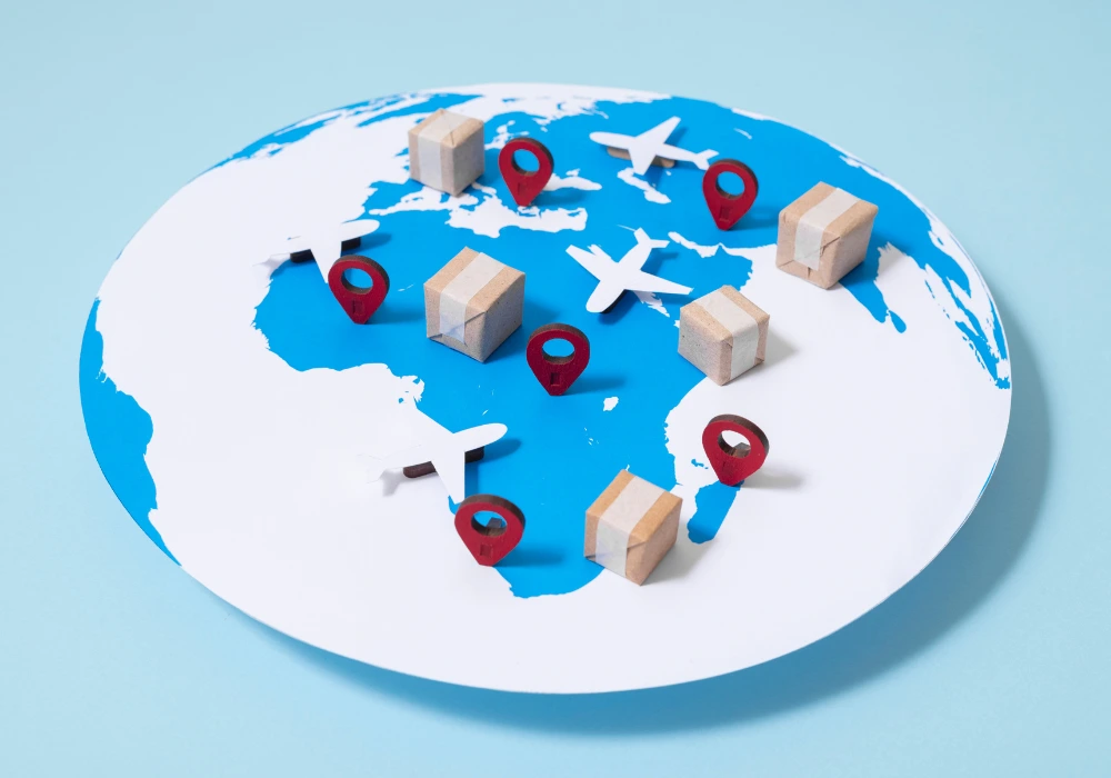 A world map in the form of a paper globe. Toy airplanes rest on different continents, and miniature cardboard boxes showing marketplace distribution nearby.
